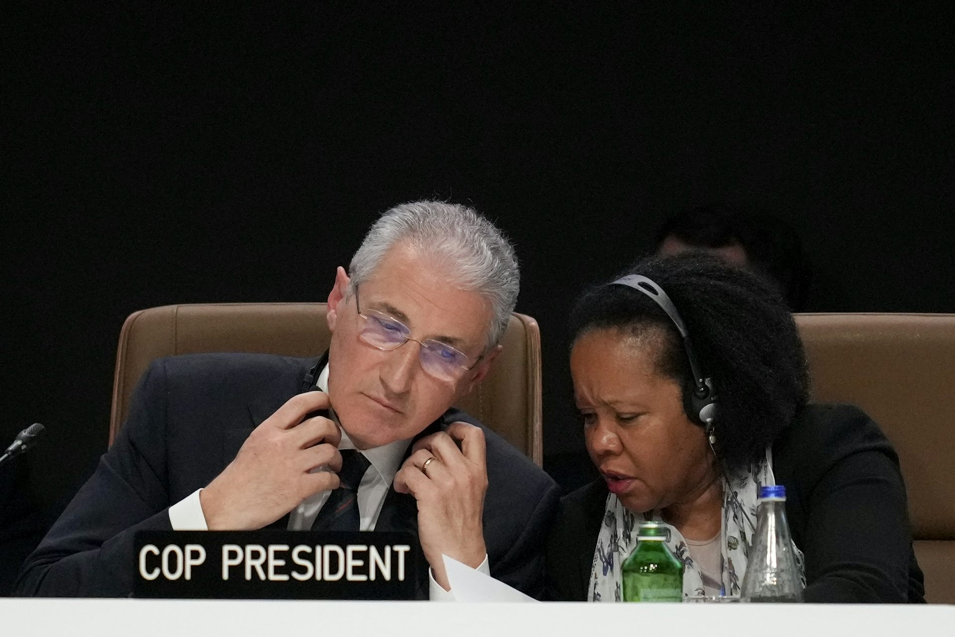 man and woman at desk wearing headphones